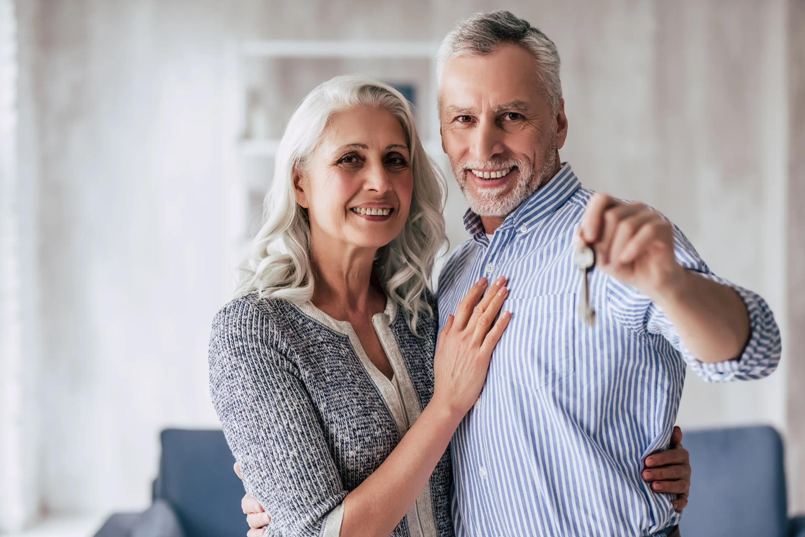 An older couple holding the keys to their new home